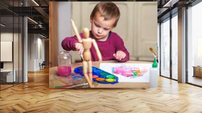 Young boy doing his creative activity of painting with watercolors at his work table. Wall mural