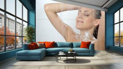 Young woman washing head with shampoo Wall mural