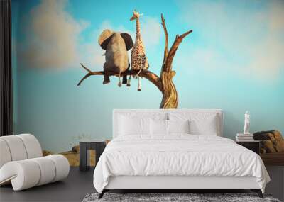 Elephant and giraffe stands on thin branch of withered tree in surreal landscape. The concept of friendship. Wall mural