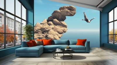 Man jumps into the ocean from a cliff. Wall mural