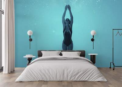 Woman swimming underwater in a sea. Wall mural