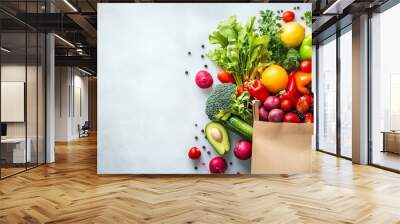 A healthy food arrangement featuring fruits and vegetables in a paper bag, set on a white background with copy space for a clean, vegan eating concept Wall mural