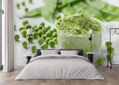 A plastic scoop filled with plant-based pea protein powder, accompanied by fresh green pea seeds, all against a white background. An isolated copy space for additional text or design elements Wall mural