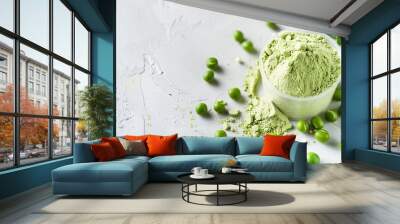 A plastic scoop filled with plant-based pea protein powder, accompanied by fresh green pea seeds, all against a white background. An isolated copy space for additional text or design elements Wall mural