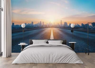 An empty asphalt road extends into a modern city skyline at sunset, offering a high-angle view that captures the urban scenery in a tranquil moment Wall mural