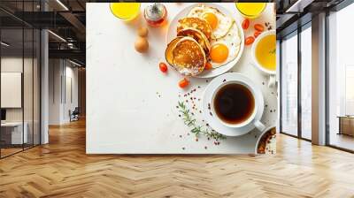 Full American breakfast including sunny-side fried eggs, roasted bacon, hash browns, pancakes, toast, orange juice, and coffee on a white background with space for text, top view Wall mural