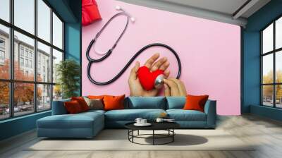 Table top view aerial image of accessories healthcare & medical with Valentines day background concept.Flat lay items for doctor using telescope checking heart rate colorful love shape on pink paper. Wall mural