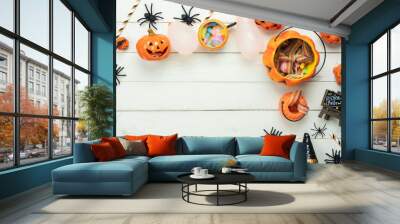 Table top view aerial image of decoration Happy Halloween day background concept.Flat lay accessories essential object to party the pumpkin & sweet candy on white wooden.Space for creative design. Wall mural