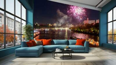 Purple fireworks explode over riverside at summer festival Wall mural