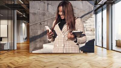 African-American businesswoman using mobile phone outside the office. Wall mural