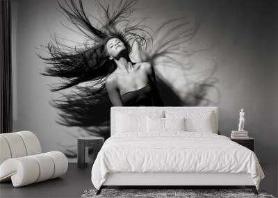 Beautiful girl with flowing hair on a gray background. Wall mural