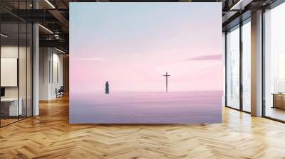 A minimalist photograph depicts a woman standing alone on a deserted beach, with a solitary wooden cross planted in the sand behind her. The soft, pastel hues of the sky and sea create a tranquil Wall mural