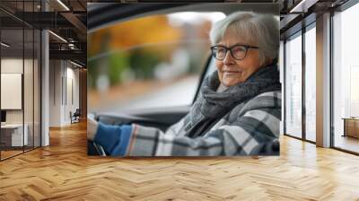 Senior woman enjoying scenic drive in modern electric vehicle Wall mural