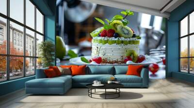 A round tart with kiwis, raspberries, mint and whipped cream on a plate with a photography studio and equipment in the background. Gourmet food photography. Wall mural