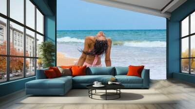 Beach woman enjoying serene luxury vacation relaxing under the sun sitting in water looking at perfect turquoise ocean  tropical getaway paradise. Girl from the back sunbathing. Wall mural