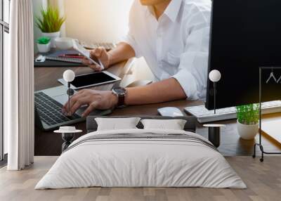 man hand using mobile and typing keyboard of laptop computer on office desk. Workspace, businessman working project creative idea for job online network. Business finance and technology concept. Wall mural