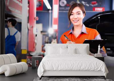 Portrait of Beautiful Asian young female mechanic in uniform with smile. Professional inspects check engine in Auto garage. Auto repair service and maintenance Concept. Wall mural