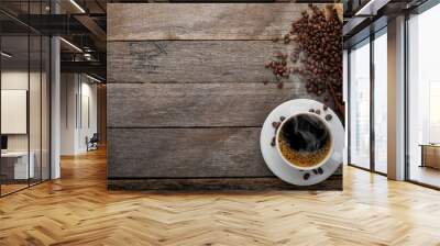 Top view above of Black hot fresh coffee with smoke and milk foam in a white ceramic cup with coffee beans roasted in burlap sack bag on wooden table background. Flat lay with copy space. Wall mural