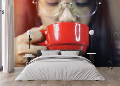 Asian women wearing glasses are holding red coffee Wall mural