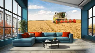 Combine harvester in action on wheat field Wall mural