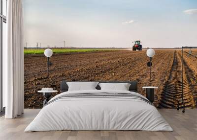 Farmer fertilizing arable land with nitrogen, phosphorus, potassium fertilizer Wall mural