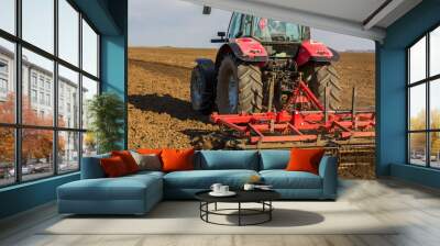 Farmer in tractor preparing land with seedbed cultivator Wall mural