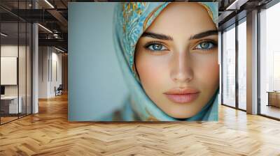 Close-up portrait of a woman wearing a blue and gold patterned headscarf Wall mural