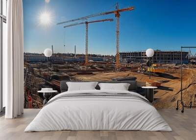 Construction site with two cranes, unfinished building, and excavated earth Wall mural