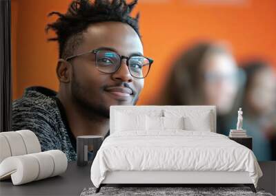 Young Black Man With Glasses Smiling in a Group Setting Wall mural