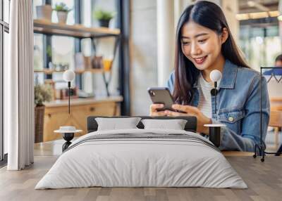 Young woman using smartphone for online shopping in a coffee shop
 Wall mural