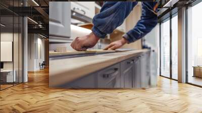 A worker install kitchen cabinets and counter of a beautifully designed kitchen. Wall mural