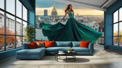 Attractive brunette girl in a long emerald dress posing on the catwalk on the roof against the background of the city, fashion concept, model in a luxurious dress against the background of Paris urban Wall mural