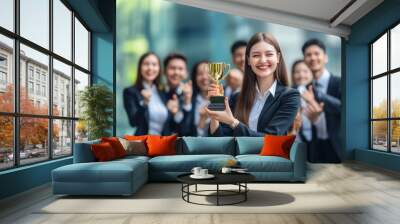 Business success concept. Happy winner businesswoman receives a business award and holding trophy with team of cheerful workers. Celebrating and congratulating their leader on great work success. Wall mural