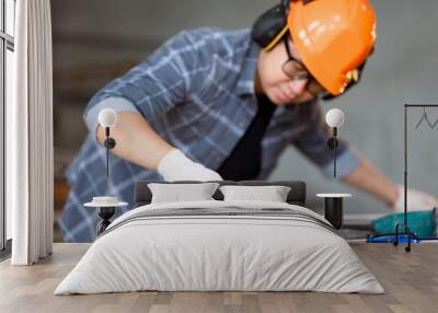 Carpenter asian man working with equipment on wooden table at under construction home or carpentry shop. Wall mural