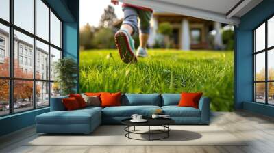 Close up of child running on green grass to new house. Child playing on garden. Wall mural