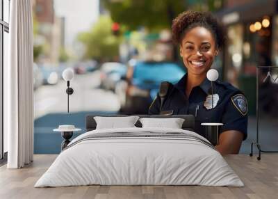 Portrait of African American women police officer standing with smiling on street. Wall mural