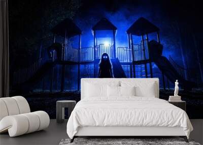 A Silhouette of a Figure with Glowing Eyes Standing on a Playground at Night Wall mural