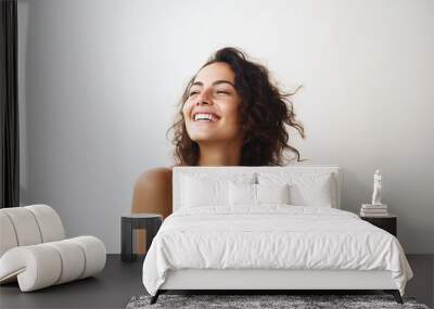 laughing woman with long dark hair in white top isolated on clean background Wall mural