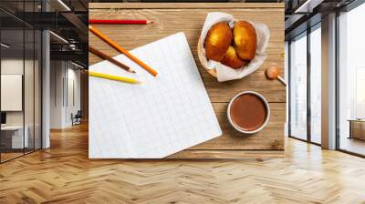 Madeleine cookie or French sponge cake alongside a school book, pencils, lollypop, candies and hot chocolate on wood background, Proust Madeleine, Flat lay. Wall mural