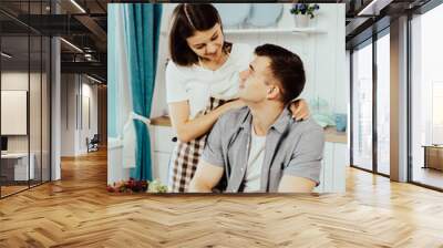 happy young couple have fun in modern kitchen indoor while preparing fresh fruits and vegetables food salad Wall mural