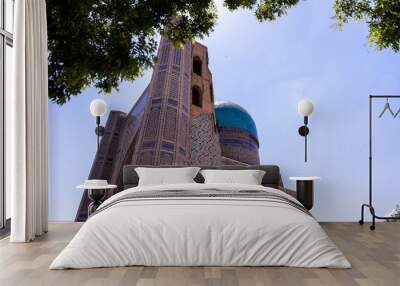 A blue dome sits atop a building with a blue roof. The building is old and has a lot of detail on it. The sky is clear and blue, and the sun is shining brightly Wall mural