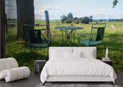 Patio Set On A Large Grassy Field With Two Chairs and One Table Wall mural