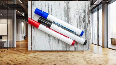 Blue, Red, Black Marker Set on White background on White Wooden Background Wall mural