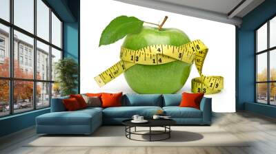 Whole green apple with measuring tape isolated on white background Wall mural