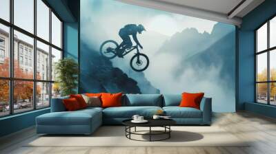 A man is riding a bike down a mountain with the sun setting in the background Wall mural