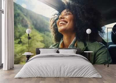 A black women rides in a car and enjoys the views of mountains and waterfalls. Auto travel. Car trip. Wall mural