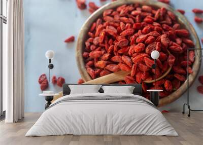 Dried  goji berries in ceramic plate with wooden spoon. Wall mural