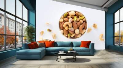 Healthy food and snack : mixed nuts in white ceramic bowl on white background from above, pistachios, almonds, hazelnuts and cashew. Wall mural