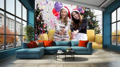 Two young Asian women in party cracker with confetti in Christmas.Two young Asian women in party cracker with confetti in Christmas. Wall mural