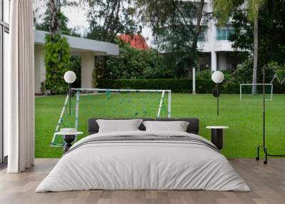 Mini football goal, mini soccer goal on the green grass field at home Wall mural